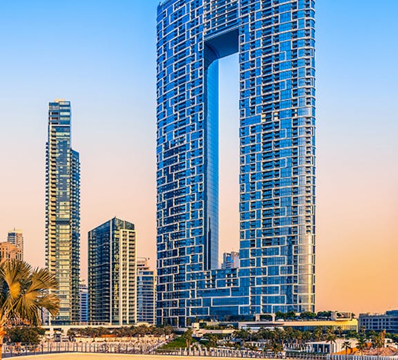 Jumeirah Beach Dubai skyline with modern skyscrapers at sunset.