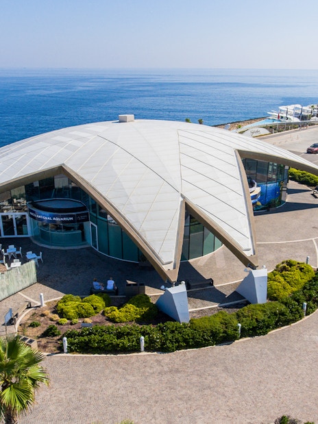 Aerial view of Malta National Aquarium with ocean backdrop.