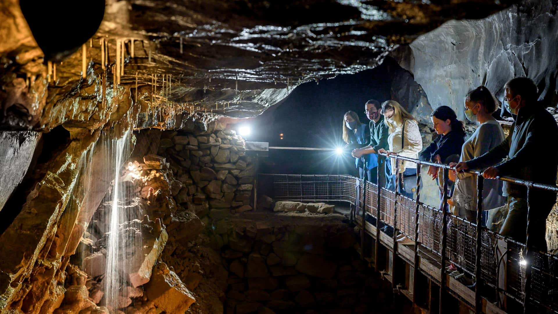 Visitors exploring Aillwee Cave with stalactites in County Clare, Ireland.