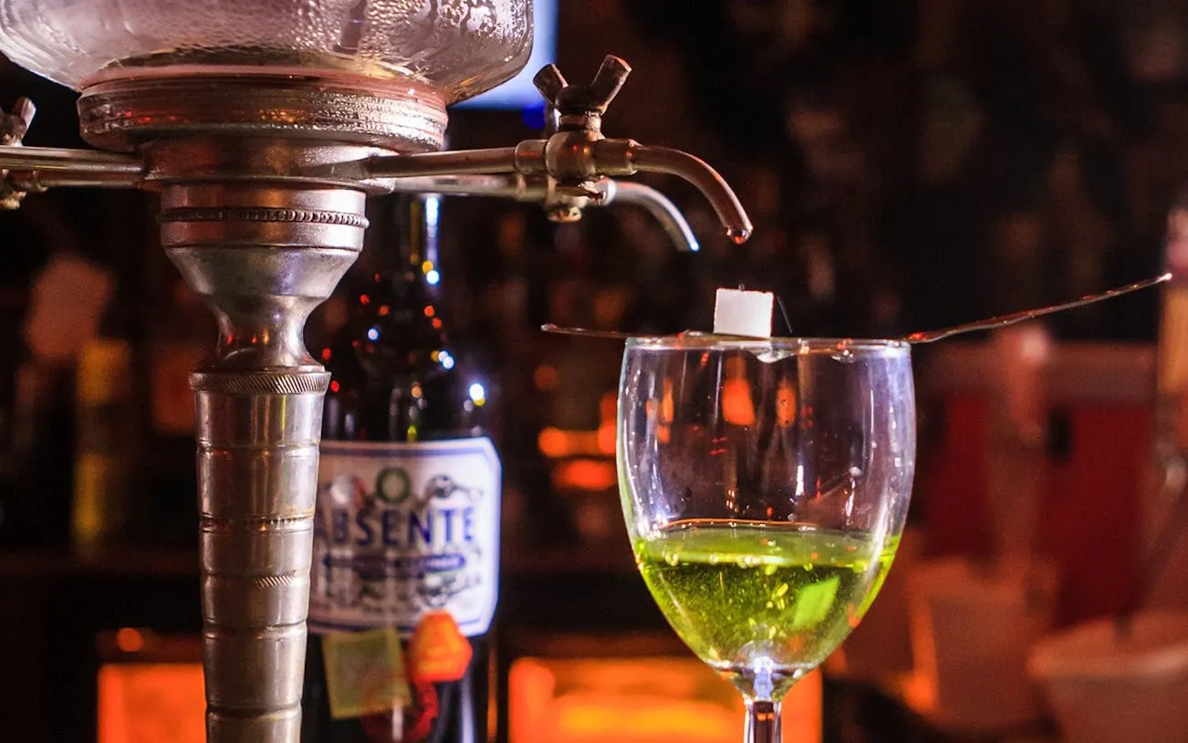 Absinthe preparation with sugar cube on spoon, New Orleans cocktail tour.