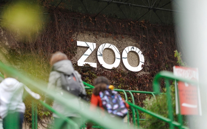 Zoo entrance sign at Edinburgh Zoo with visitors walking up stairs.