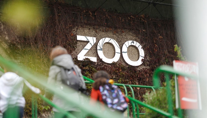 Zoo entrance sign at Edinburgh Zoo with visitors walking up stairs.