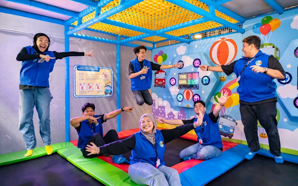 Adults enjoying activities at Tayo Station indoor playground.