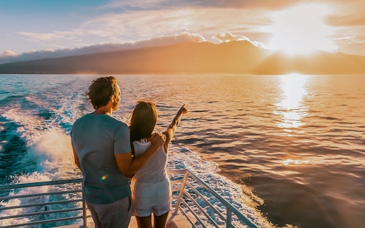 Couple enjoying sunset on a boat during Dolphin Tour in Taormina.