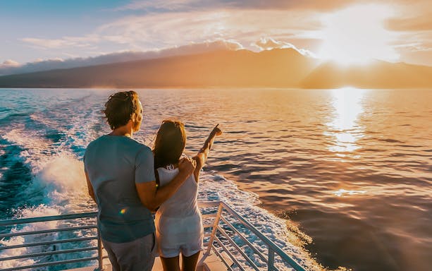Couple enjoying sunset on a boat during Dolphin Tour in Taormina.