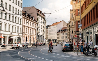 Berlin street scene with historic buildings and tram tracks, part of self-guided city exploration game.