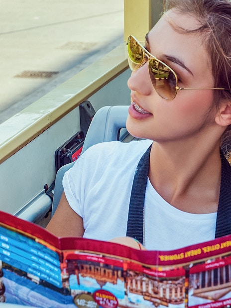 Woman examining Big Bus tour map on an open-top bus.