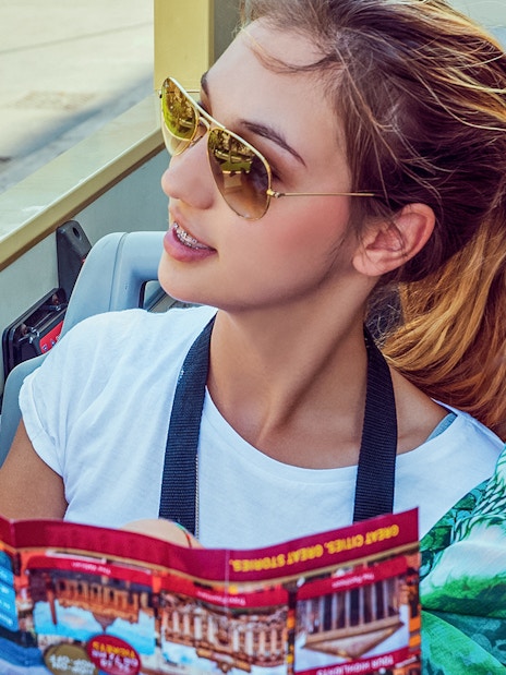 Woman examining Big Bus tour map on an open-top bus.