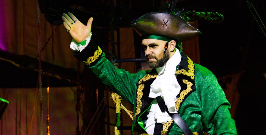 Pirate actor in green costume performing at Pirates Dinner Adventure Show.
