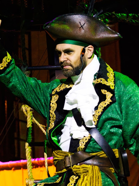 Pirate actor in green costume performing at Pirates Dinner Adventure Show.