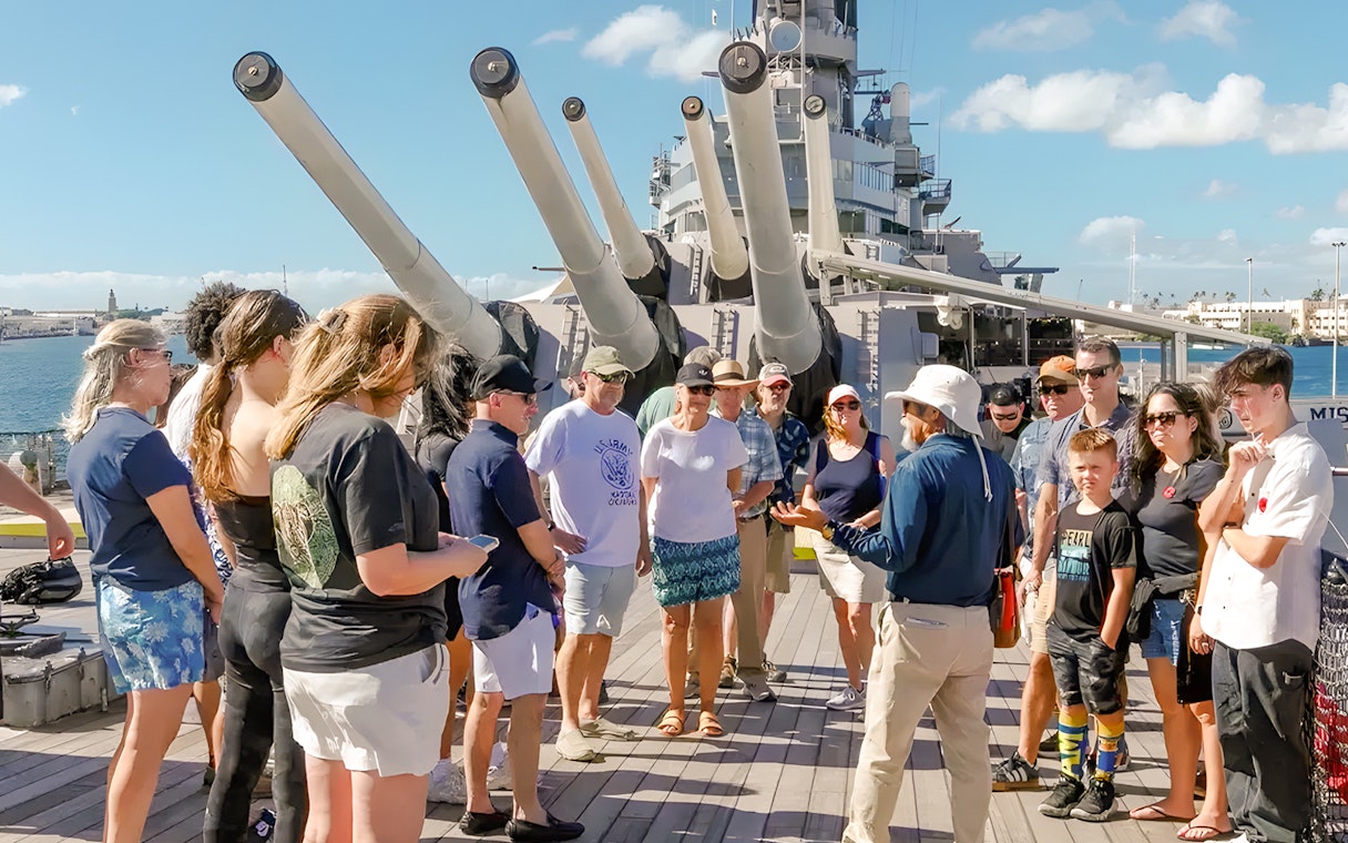 Guide explaining to guests on the deck of USS Missouri in Pearl Harbor.
