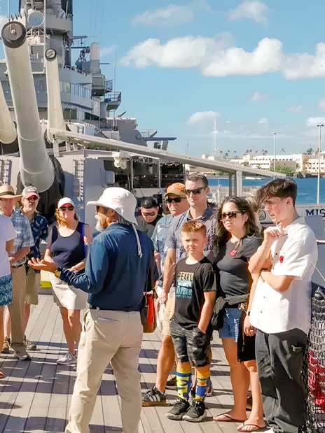 Guide explaining to guests on the deck of USS Missouri in Pearl Harbor.