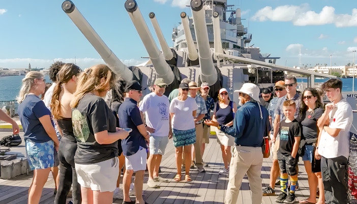Guide explaining to guests on the deck of USS Missouri in Pearl Harbor.