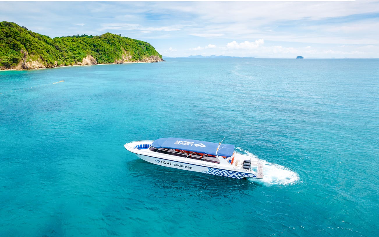 Speed boat traveling towards Surin Island in clear blue waters.