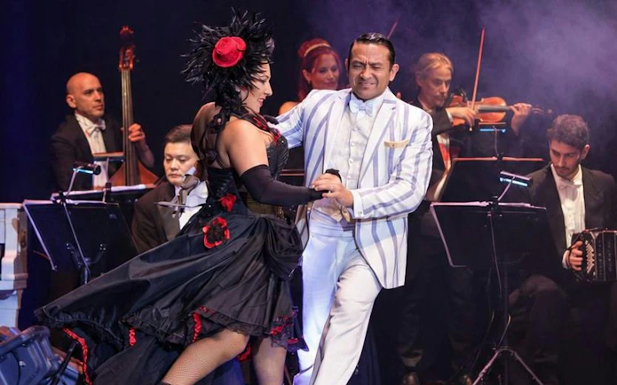 Tango dancers performing at Piazzolla Tango Show with live orchestra in Buenos Aires.