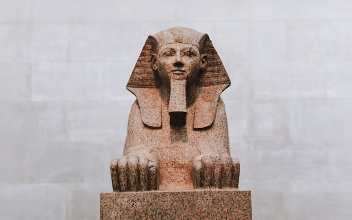 Granite statue of the Sphinx of Hatshepsut in a museum setting.