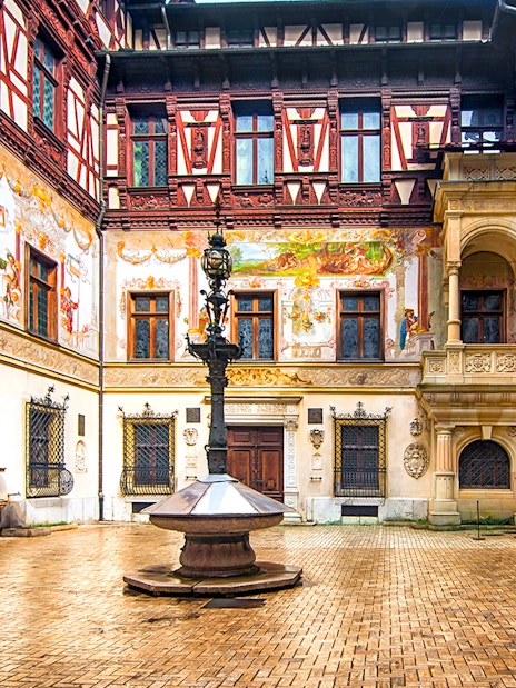 Inner courtyard of Peles Castle with ornate architecture and central fountain.