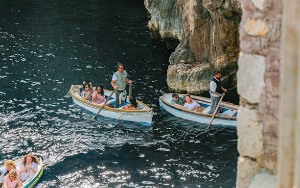 Tourists with guide in rowboats entering Blue Grotto, Capri, Italy.