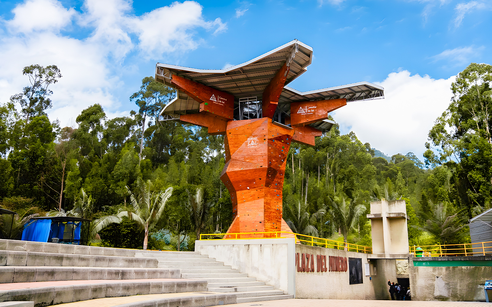 Climbing wall at Salt Cathedral of Zipaquirá, Colombia, surrounded by lush greenery.