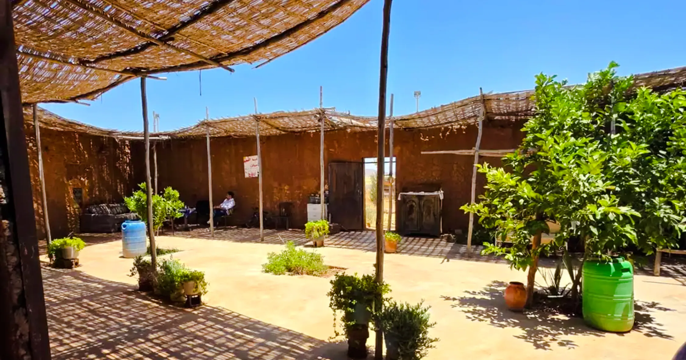 Outdoor cooking area at a women's cooperative farm near Marrakech, featuring plants and rustic decor.