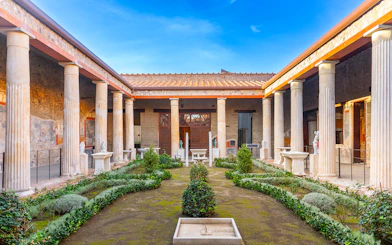Pompeii garden with ancient columns and greenery in Italy.