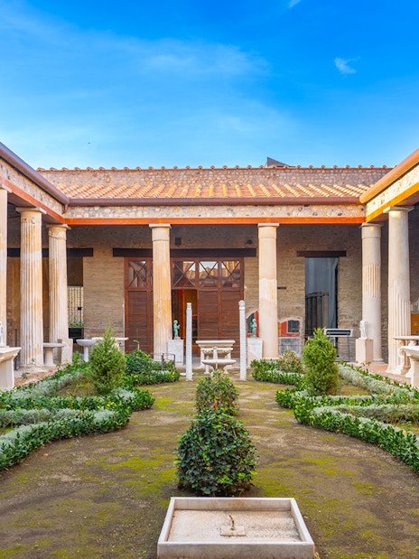 Pompeii garden with ancient columns and greenery in Italy.