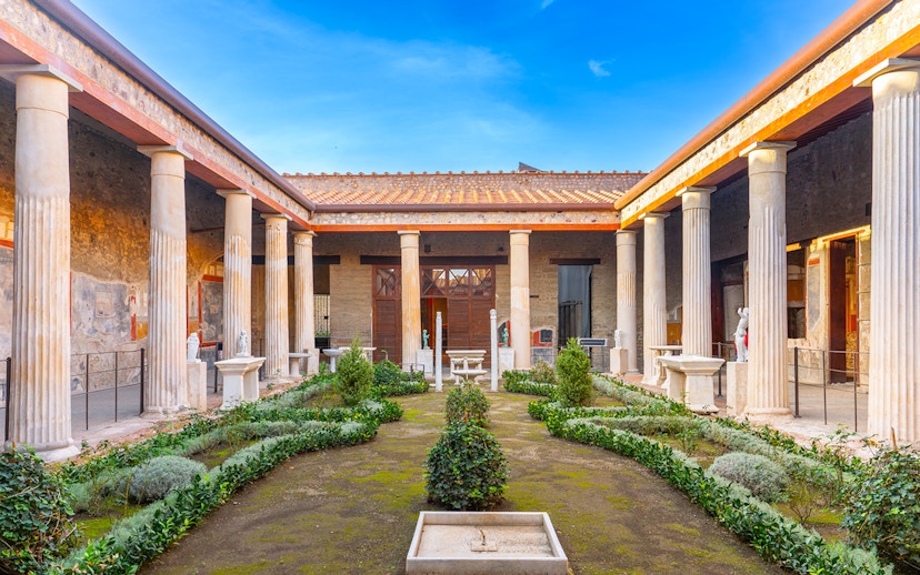 Pompeii garden with ancient columns and greenery in Italy.