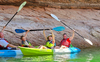 Kayakers smiling and holding paddles in Antelope Canyon, Page.