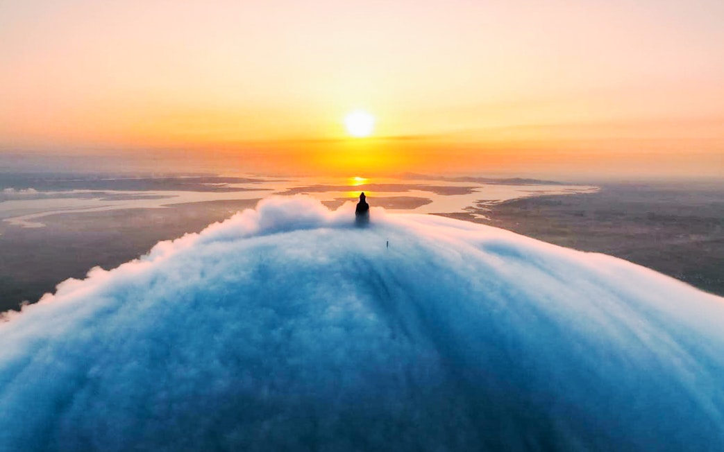 Sunrise view from Van Son Peak, Ba Den Mountain, with clouds and distant landscape.