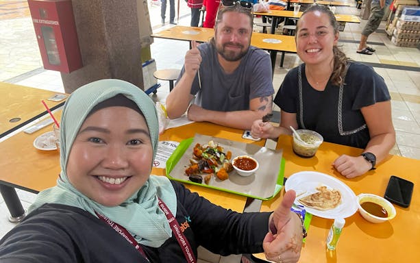 Tourists enjoying a food tasting at Little India Hawker Street, Singapore.