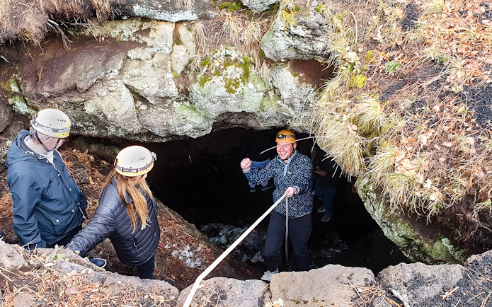 Tourists entering a cave during Mount Etna exploration tour.