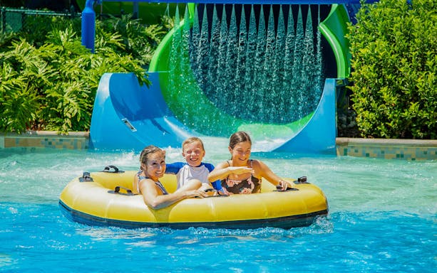 Family enjoying inflatable tube ride at Amverton Riverine Splash.