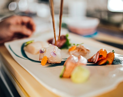 Close up shot of a professional sushi chef preparing sashimi in a restaurant.