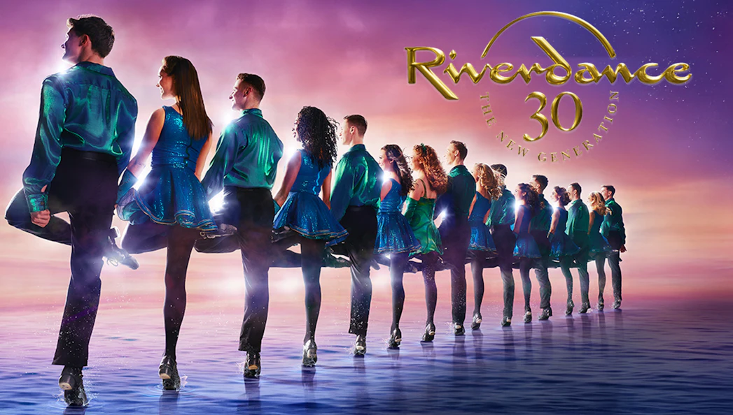 Dancers performing Riverdance against a sunset backdrop.
