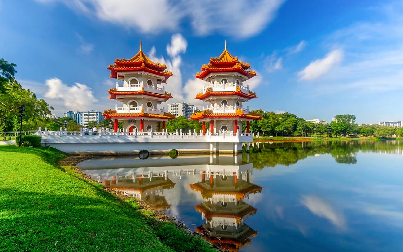 Twin pagodas reflected in a lake at a park in Singapore, part of the Penang & Phuket cruise itinerary.