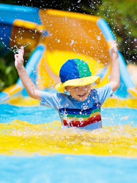 Child enjoying water slide at a waterpark.