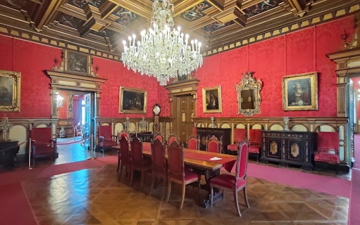 Miramare Castle Throne Room with chandelier and red furnishings in Trieste, Italy.