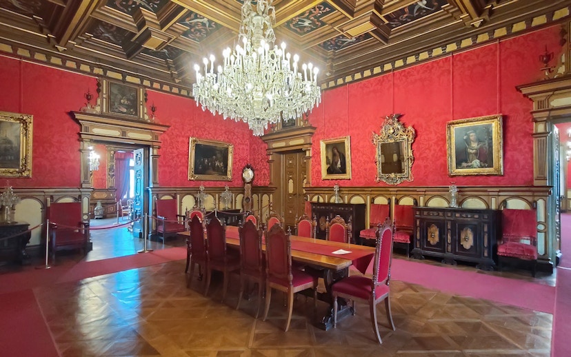 Miramare Castle Throne Room with chandelier and red furnishings in Trieste, Italy.