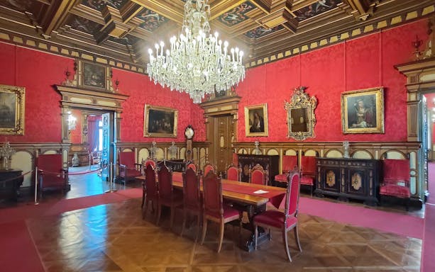 Miramare Castle Throne Room with chandelier and red furnishings in Trieste, Italy.