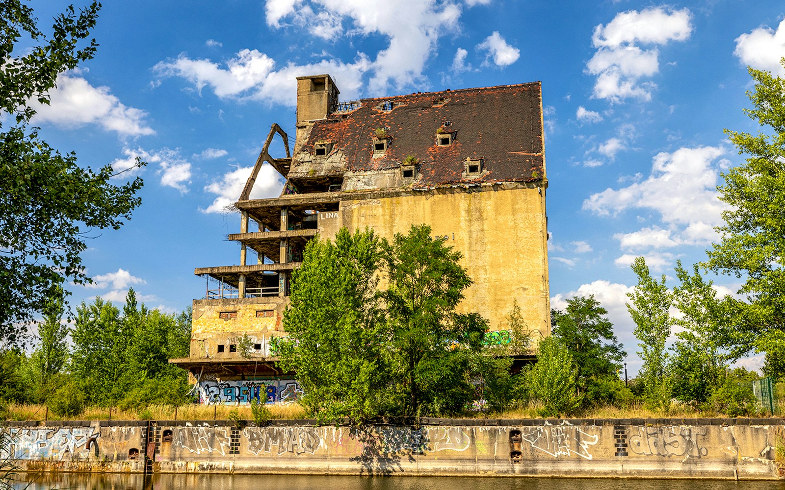 Old warehouse buildings at the port of Lindenau in Leipzig with boats docked along the canal.