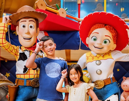 Children interacting with Pixar Pals characters on a Disney cruise.