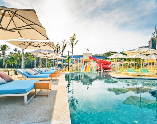 Poolside loungers and water slides at Splash Tribe resort.