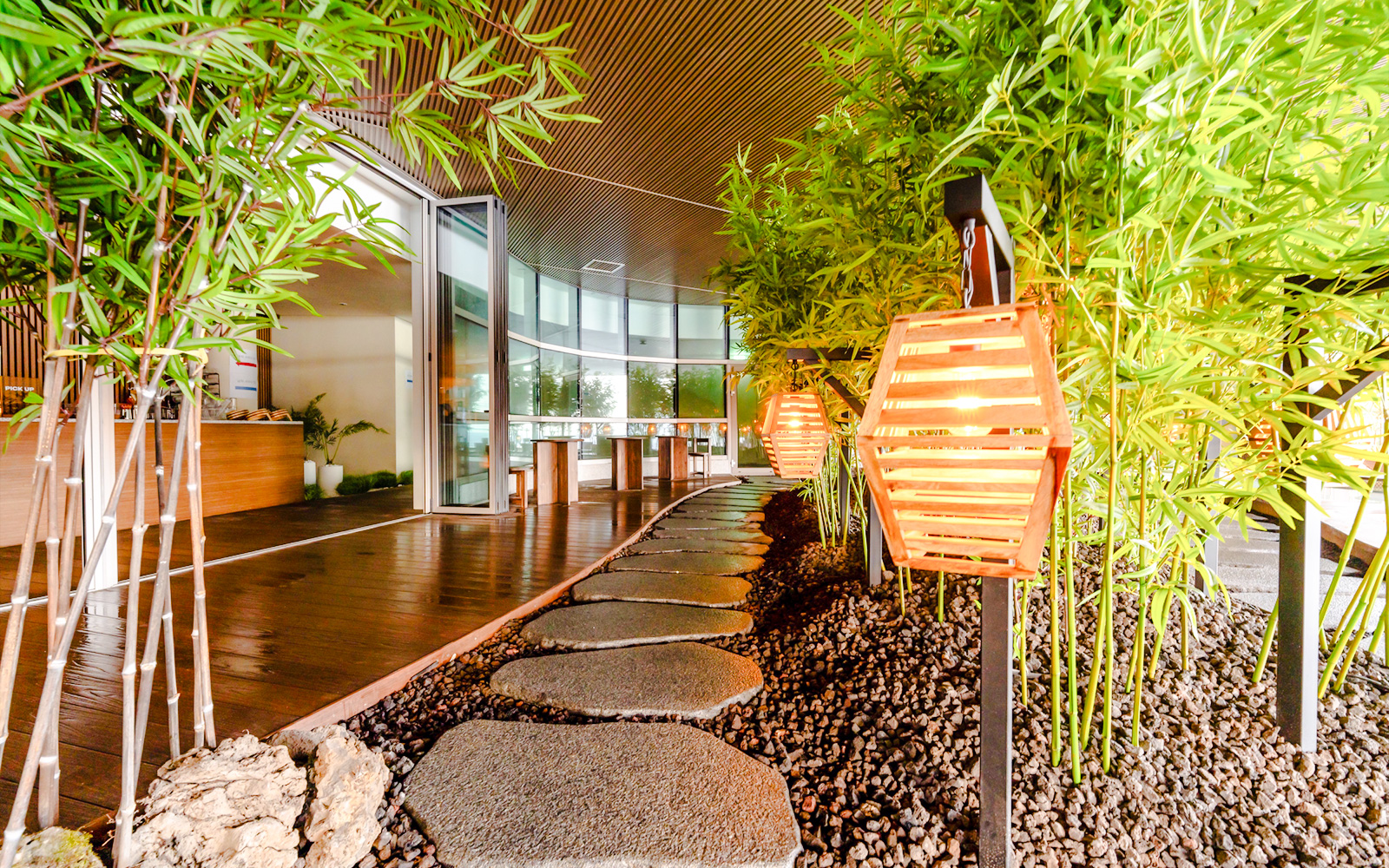 Stone pathway with glowing lanterns and bamboo decor in Club D Oasis spa area.
