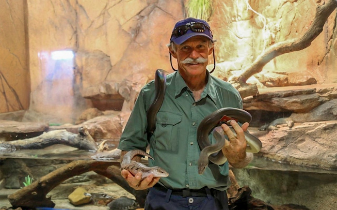 Man holding snakes at Crocosaurus Cove, Darwin, Australia.