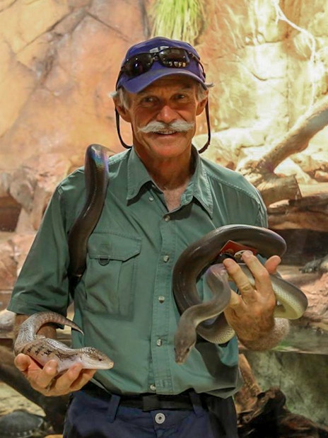 Man holding snakes at Crocosaurus Cove, Darwin, Australia.