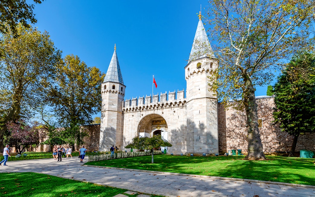 Gate of Salutation at Topkapi Palace, Istanbul, with visitors walking nearby.