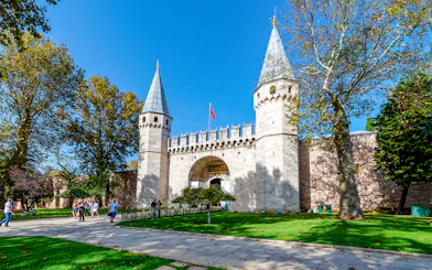 Gate of Salutation at Topkapi Palace, Istanbul, with visitors walking nearby.