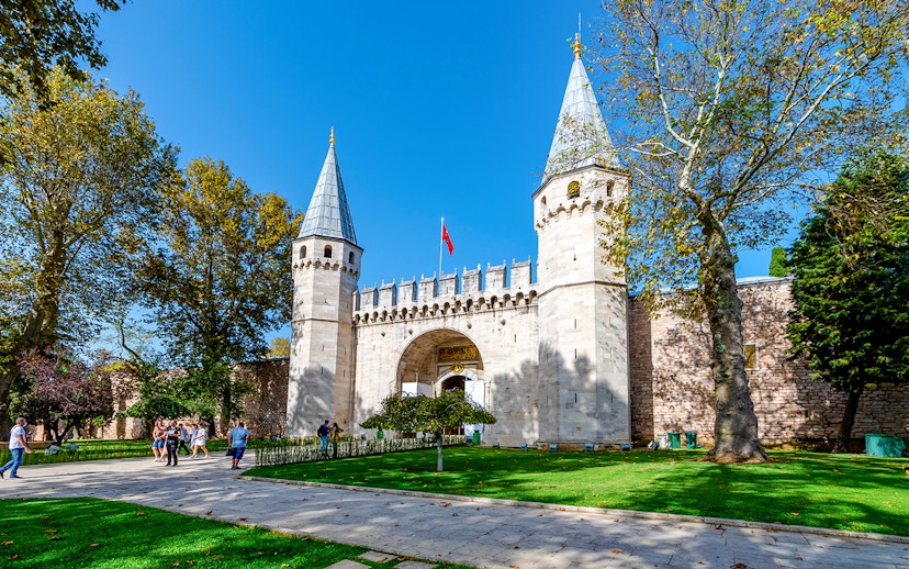 Gate of Salutation at Topkapi Palace, Istanbul, with visitors walking nearby.