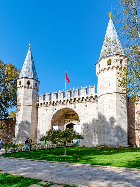 Gate of Salutation at Topkapi Palace, Istanbul, with visitors walking nearby.
