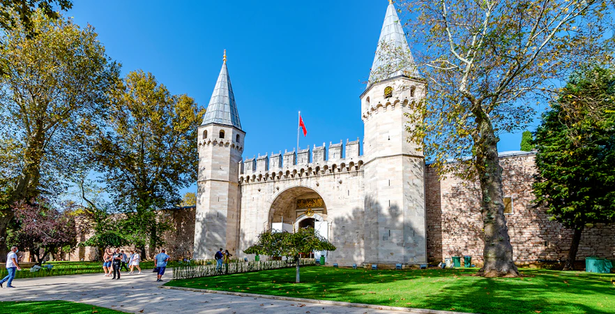 Gate of Salutation at Topkapi Palace, Istanbul, with visitors walking nearby.